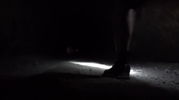 Un tizio con una lanterna in una caverna buia. — Video Stock