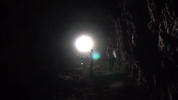 Fény egy hosszú barlang végén és gyerekek. — Stock videók