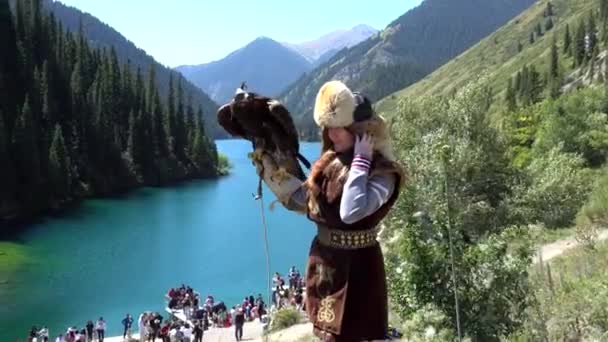 Une fille vêtue de vêtements traditionnels kazakhs et un aigle — Video