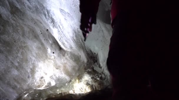 Ein Kerl in einer Eishöhle mit einem Laternenlicht. — Stockvideo