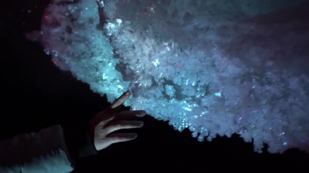 A woman hand on the background of an ice cave. — Stock video