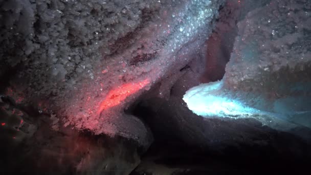 En una cueva de hielo con iluminación de colores de linternas — Vídeo de stock