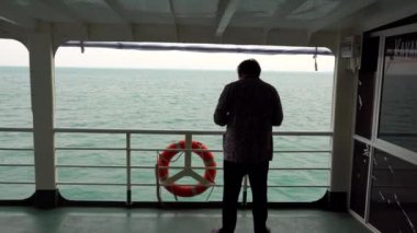 A man stands on the ferry. Travel by water.
