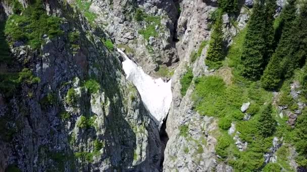 Top view of steep mountain cliffs and an ice cave. — Stock Video