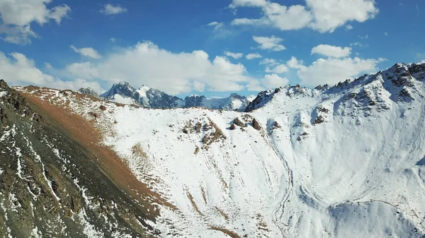 Snow-capped mountains and a lake. View from top.