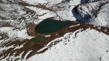 Karla kaplı dağlar ve bir göl. Yukarıdan görüntüle.