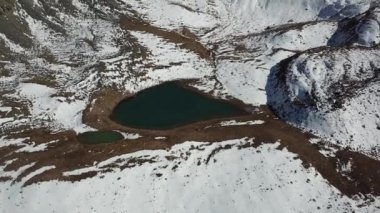 Karla kaplı dağlar ve bir göl. Yukarıdan görüntüle.