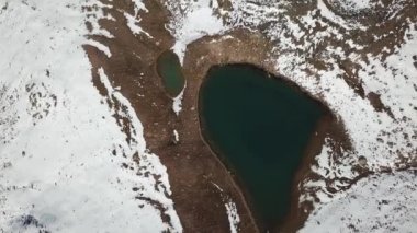 Karla kaplı dağlar ve bir göl. Yukarıdan görüntüle.