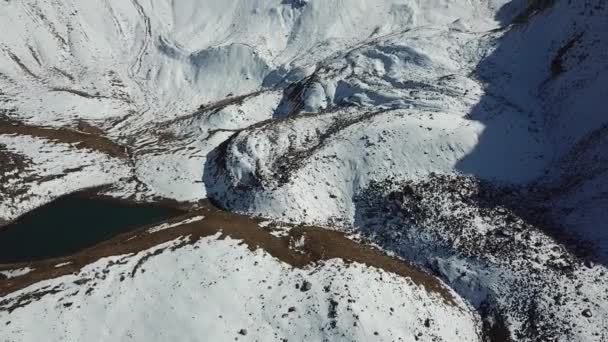 Karla kaplı dağlar ve bir göl. Yukarıdan görüntüle. — Stok video
