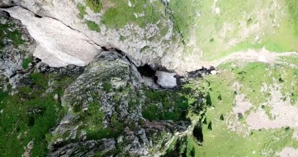 Ovanifrån av branta bergsklippor och en isgrotta. — Stockvideo