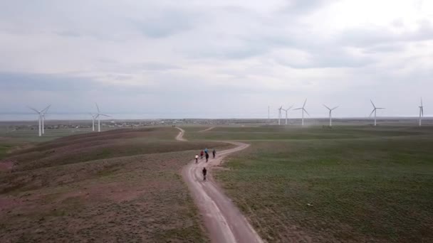 Un groupe de cyclistes longe les moulins à vent. — Video