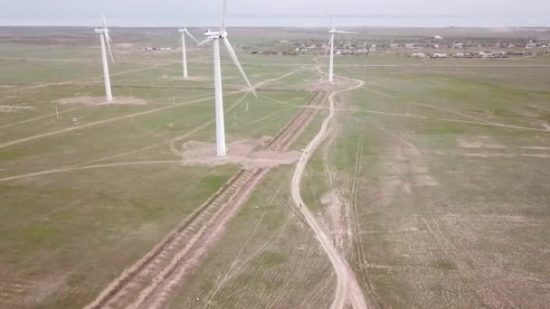A group of cyclists rides along the windmills. — Stock Video