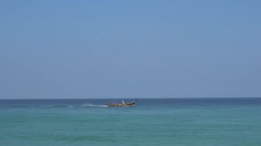 İnsanlar geleneksel bir Tayland teknesiyle denize açılıyorlar..
