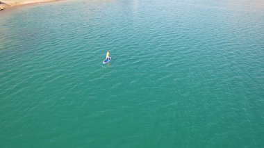 Bir grup insan gölde sup sörfü yapıyor..