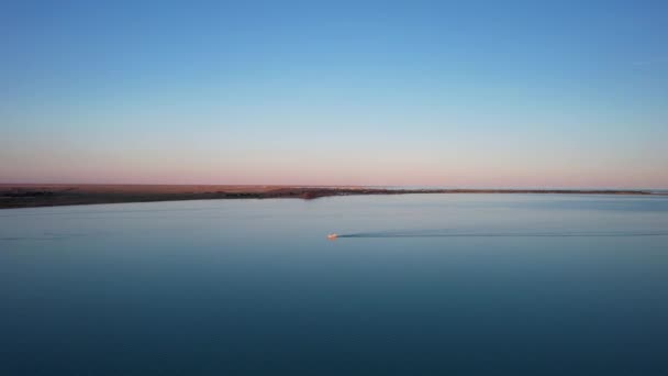 ボートは日没時にバルカシュ湖を航海する。. — ストック動画
