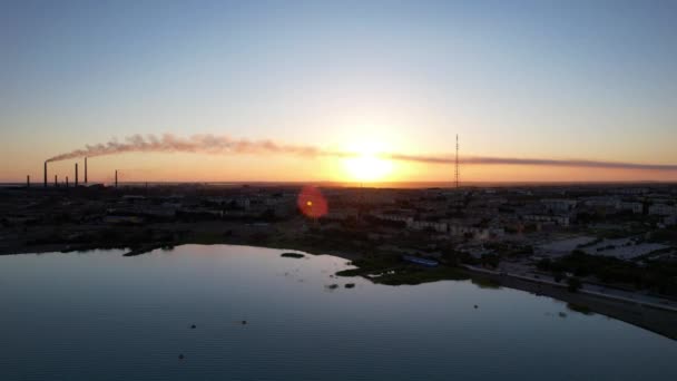 Un lago, una fábrica y una ciudad en una hermosa puesta de sol — Vídeo de stock