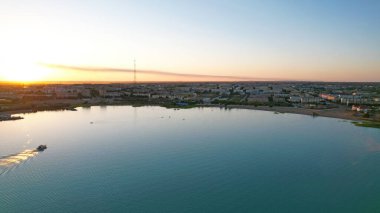 Tekne gün batımında şehrin yakınındaki körfezde yola çıkıyor.