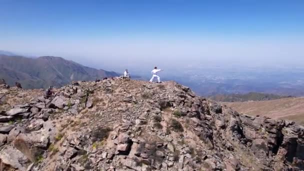 在高山之间的山顶上练习空手道. — 图库视频影像