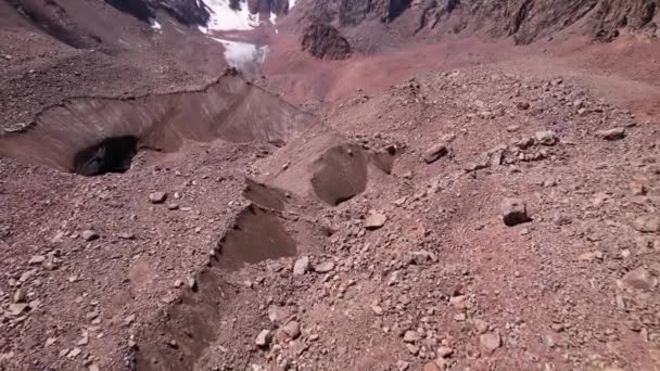 Ein Moränensee inmitten eines Gletschers, der mit Felsen bedeckt ist — Stockvideo