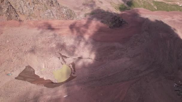 Ein Moränensee inmitten eines Gletschers, der mit Felsen bedeckt ist — Stockvideo