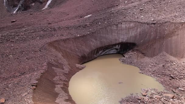 En moränsjö bland en glaciär täckt med stenar — Stockvideo