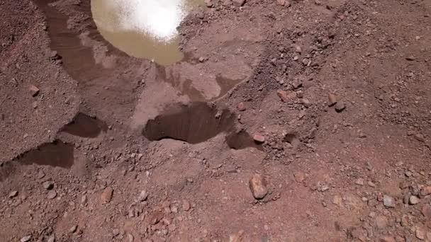 Una grieta en un glaciar cubierto de rocas. — Vídeos de Stock