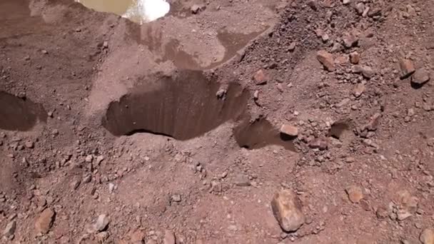 Una grieta en un glaciar cubierto de rocas. — Vídeos de Stock