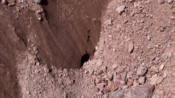 Una grieta en un glaciar cubierto de rocas. — Vídeos de Stock