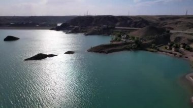 Adaları ve kayaları olan bir gölün üzerinde uçuyorlar..