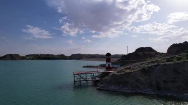 Gölün kıyısında beyaz ve kırmızı deniz feneri
