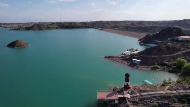 Farol branco e vermelho na margem do lago — Vídeo de Stock