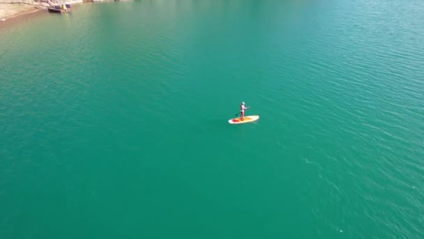 Um tipo vai comer surf num lago perto da costa.. — Vídeo de Stock