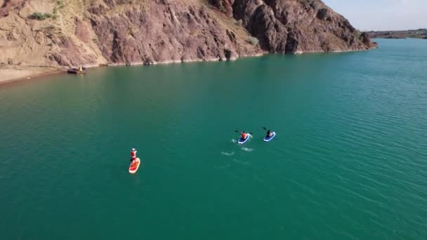 Un gruppo di persone cavalcano sup surf nel lago. — Video Stock
