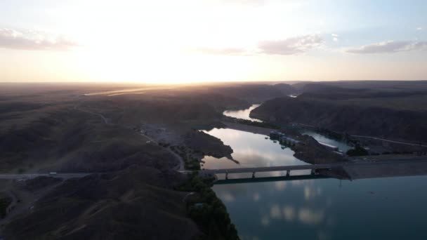 Coucher de soleil avec vue sur le barrage et le pont. — Video