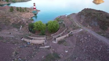 Gölün kıyısında beyaz ve kırmızı deniz feneri