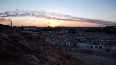 Fabrika dumanı manzaralı destansı bir gün batımı.