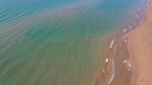 海は波で黄色い砂に触れる きれいなビーチとエメラルド水のドローンからのトップビュー 太陽の光線は水の中に反射される 真っ青な空 リラクゼーションのための場所 カッチャガイ — ストック写真