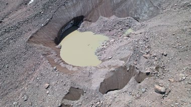Kayalarla kaplı bir buzulun arasında moraine gölü.