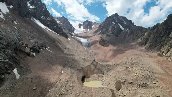 Un lago de morrena entre un glaciar cubierto de rocas —  Fotos de Stock