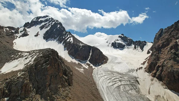Buzla kaplı yüksek kayalık dağlar. — Stok fotoğraf