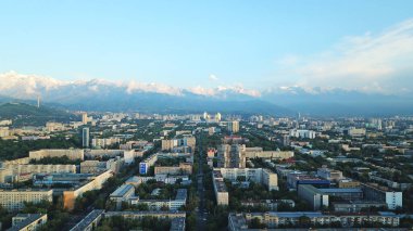 Almaty şehrinin üzerinde parlak renkli günbatımı.