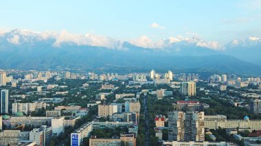 Almaty şehrinin üzerinde parlak renkli günbatımı.