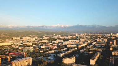 Almaty şehrinin üzerinde parlak renkli günbatımı.