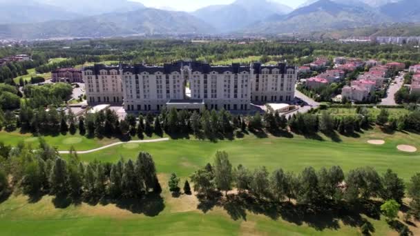 Pole golfowe i hotel na tle gór — Wideo stockowe