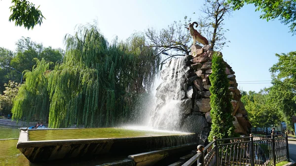 Künstlicher Wasserfall mit Statue im Stadtpark — Stockfoto