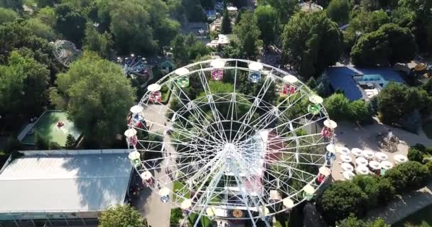 En stadspark med åkattraktioner och pariserhjul. — Stockvideo
