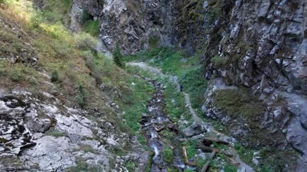 Sentiero di montagna in gola con un fiume e un turista — Video Stock