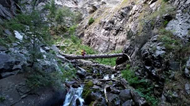 El tipo está sentado en un gran árbol sobre el río.. — Vídeos de Stock