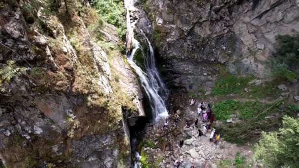 Un grupo de personas está de pie cerca de la cascada. — Vídeos de Stock