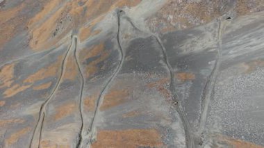 Hava perspektifi engebeli arazide dolambaçlı yollar, zengin dokular ve renkler sergiliyor, doğal güzelliği ve manzaranın karmaşıklığını yakalıyor, kamera kademeli olarak yakınlaşıyor